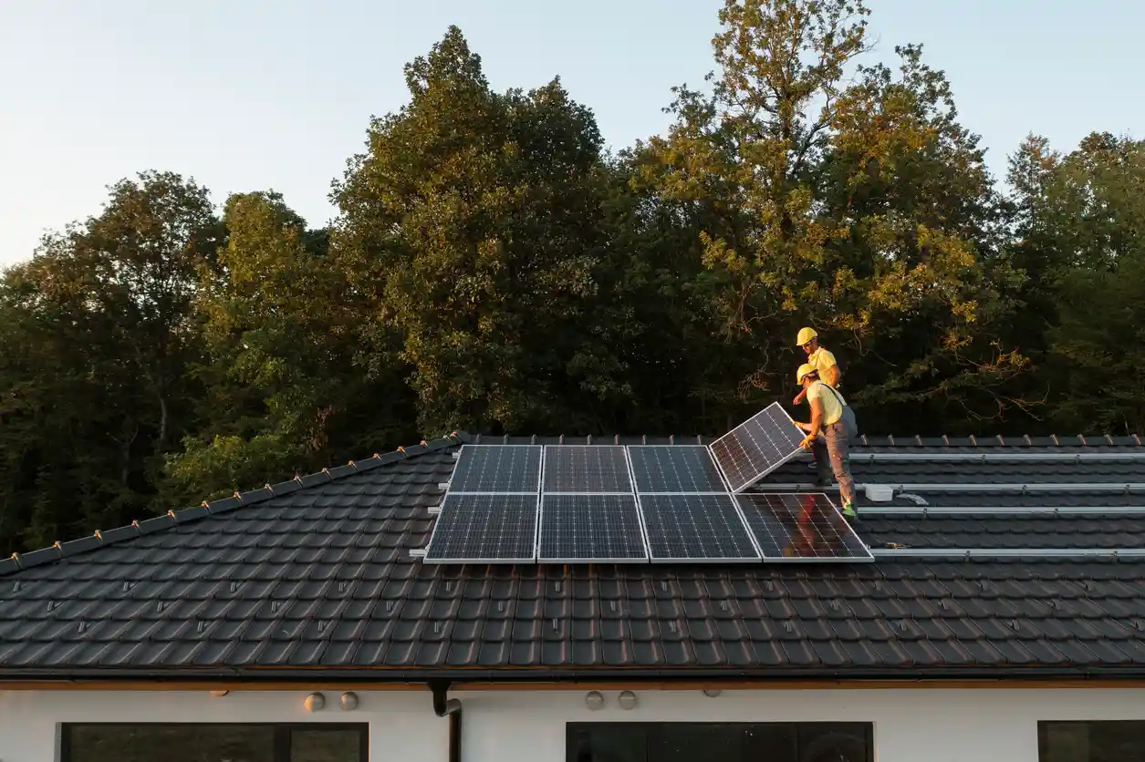 Especialistas instalando painéis solares no telhado de uma residência, promovendo energia renovável e sustentabilidade.
