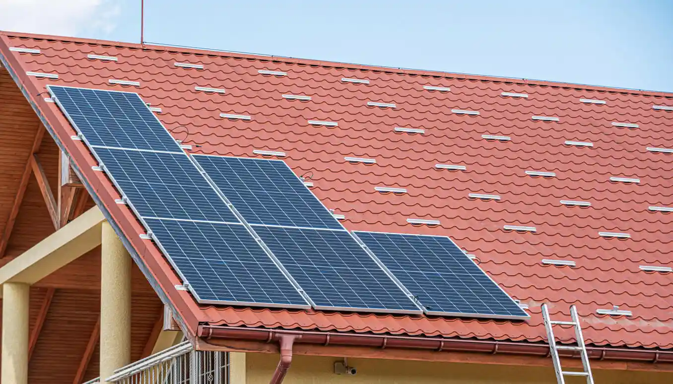 Painel solar instalado em telhado de casa com telhas vermelhas, promovendo energia sustentável e economia de energia.