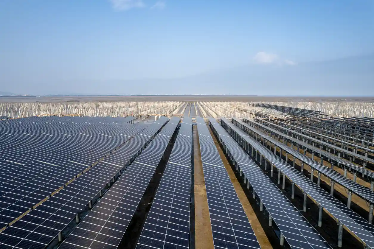 Vista aérea de um grande campo de painéis solares no Brasil, representando a crescente adoção de energia solar no país. Soluções sustentáveis e renováveis para o futuro.