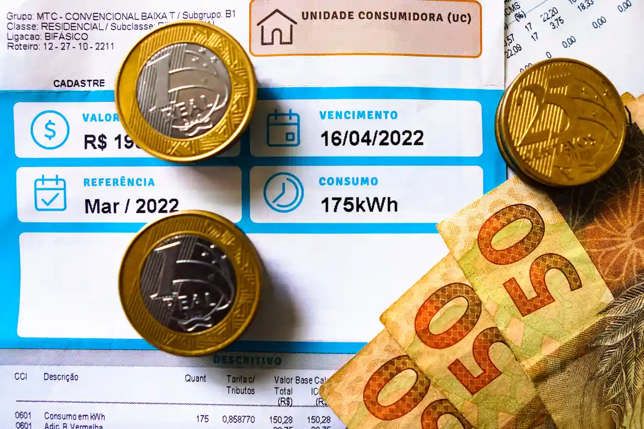 Contas de energia elétrica com moedas e cédulas de dinheiro, foco na documentação de consumo e valor de energia em kWh, otimizadas para palavra-chave de contas de energia