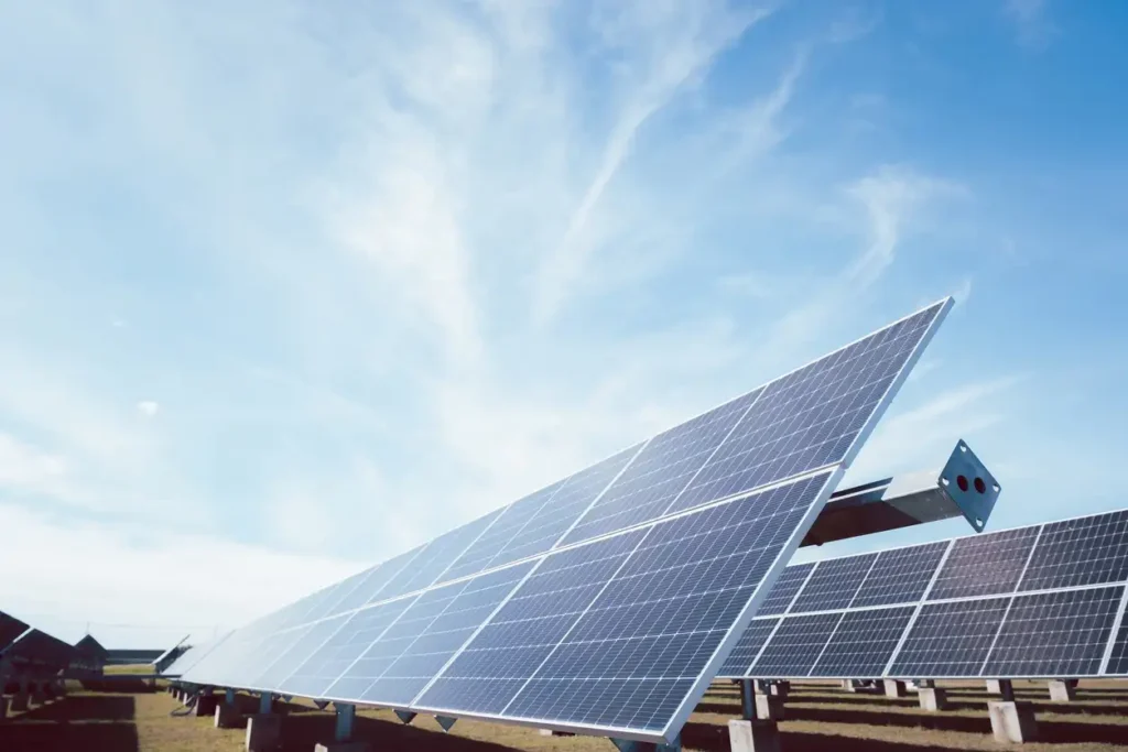 Painéis solares ao ar livre captando luz solar direta para geração de energia renovável. Instalação de energia solar fotovoltaica em campo aberto, com céu limpo ao fundo.