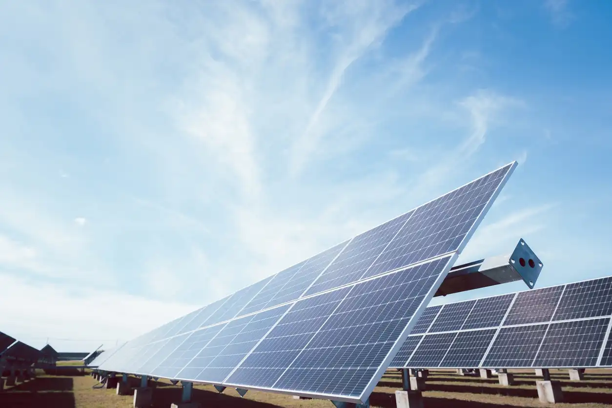 Painéis solares ao ar livre captando luz solar direta para geração de energia renovável. Instalação de energia solar fotovoltaica em campo aberto, com céu limpo ao fundo.