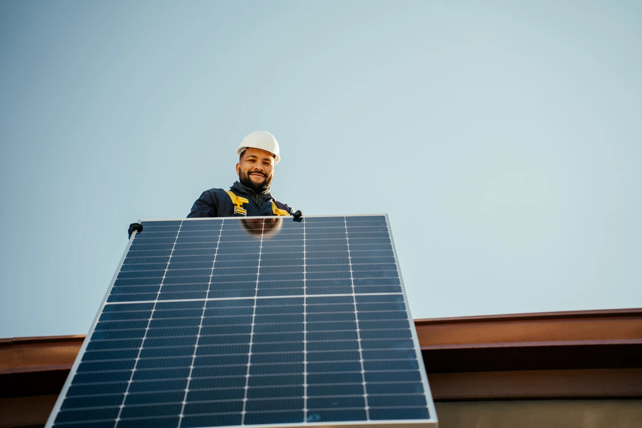 Engenheiro instalando uma placa solar em telhado, explicando como calcular a geração de kWh de uma placa solar.
