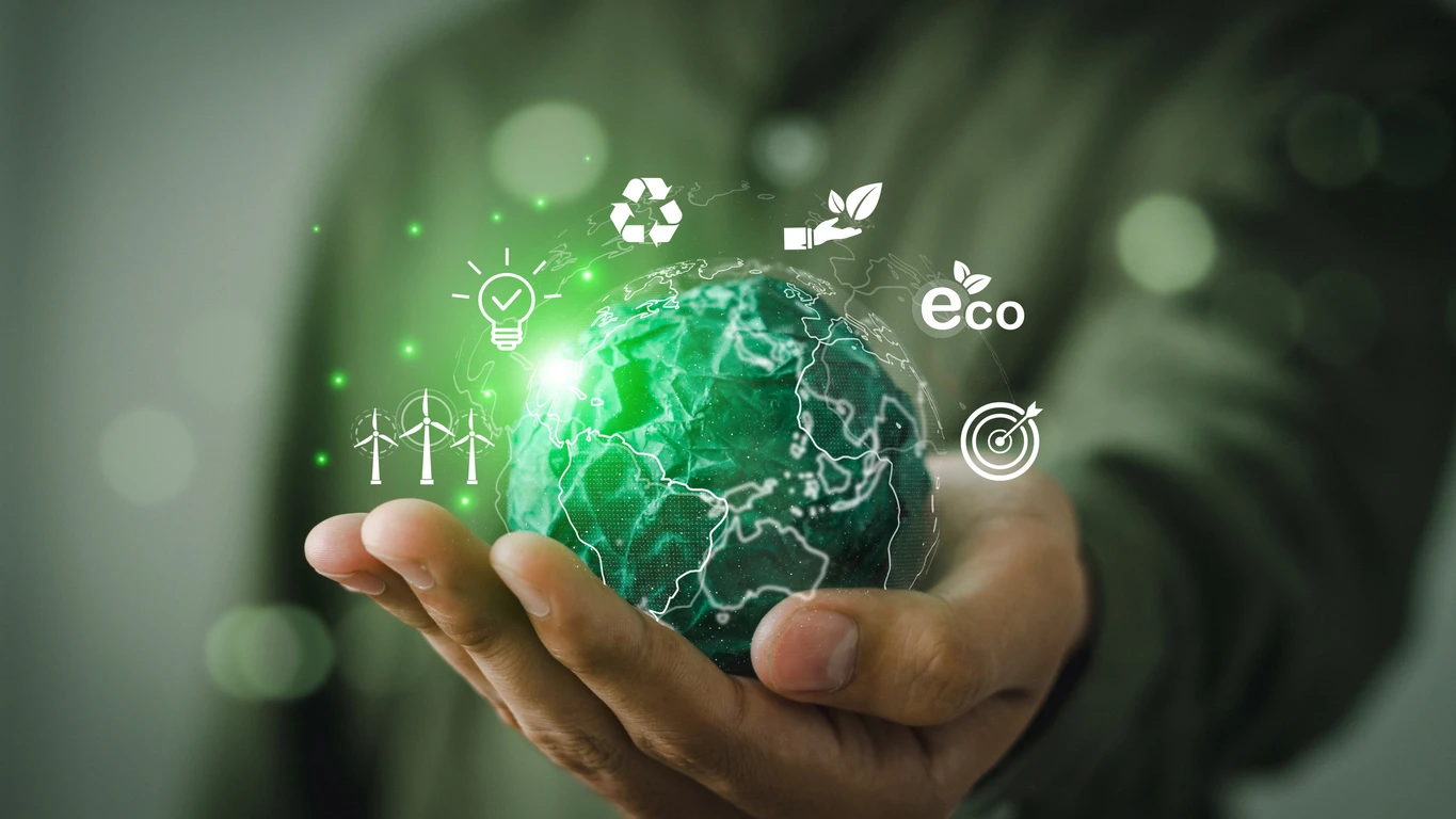 Imagem de uma mão segurando uma representação digital do planeta Terra com ícones relacionados à energia limpa, energia verde e sustentável ao redor, destacando a importância do uso de energias renováveis para um planeta mais ecológico.