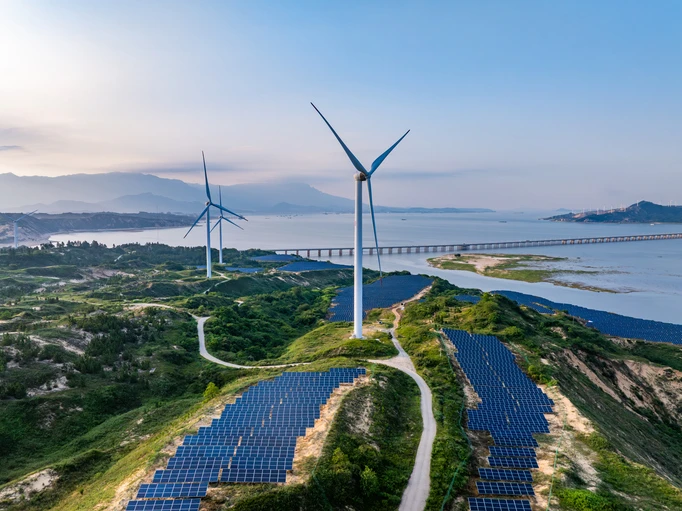 Painel de energia solar com turbinas eólicas em uma paisagem costeira, promovendo energia renovável e sustentável com painéis solares e aerogeradores.